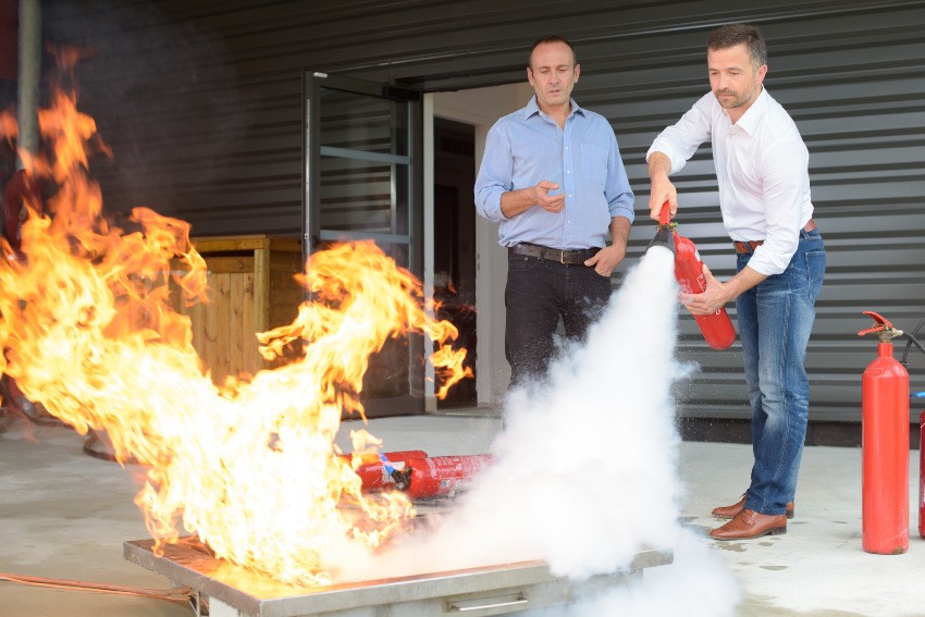 Zwei Männer üben den Umgang mit einem Feuerlöscher