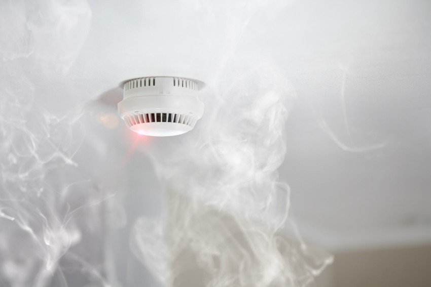 Ein photoelektrischer Rauchmelder, der an der Zimmerdecke angebracht ist, schlägt Alarm 