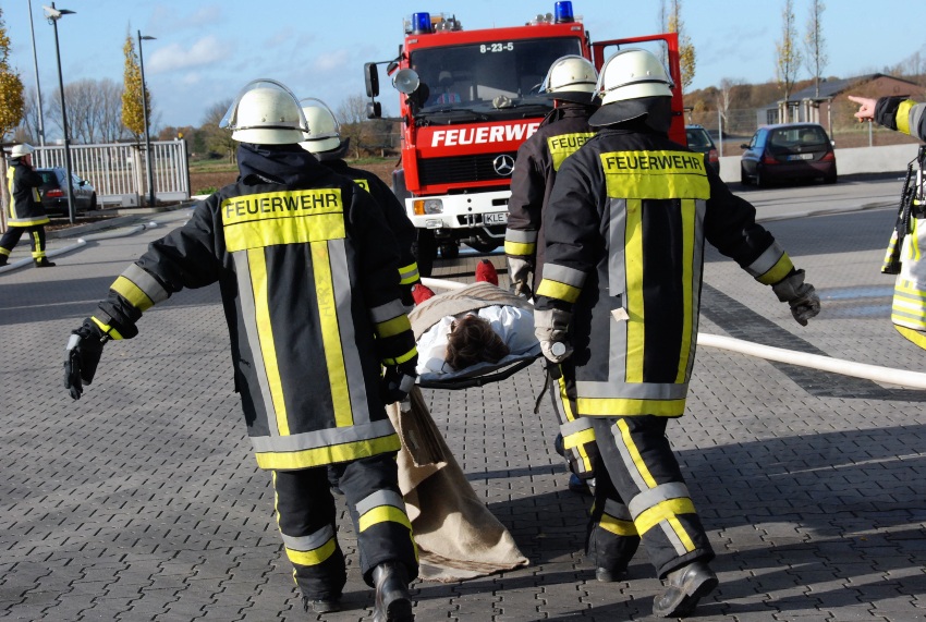 Feuerwehrleute transportieren eine verunfallte Person auf einer Liege ab